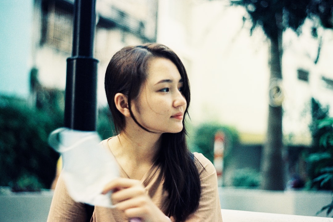 woman in white long sleeve shirt holding white paper