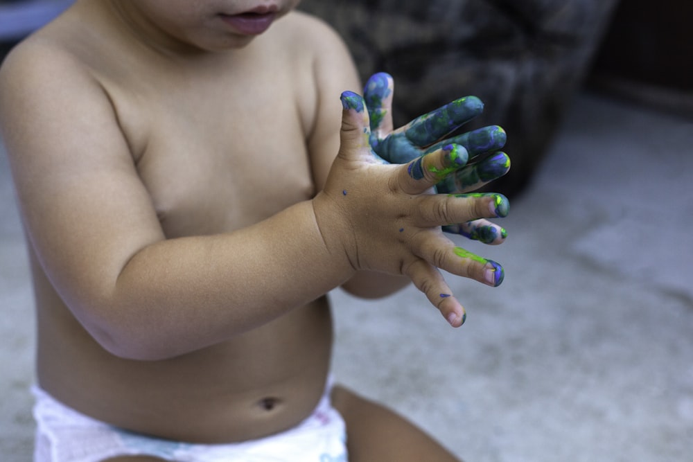 topless child with green manicure