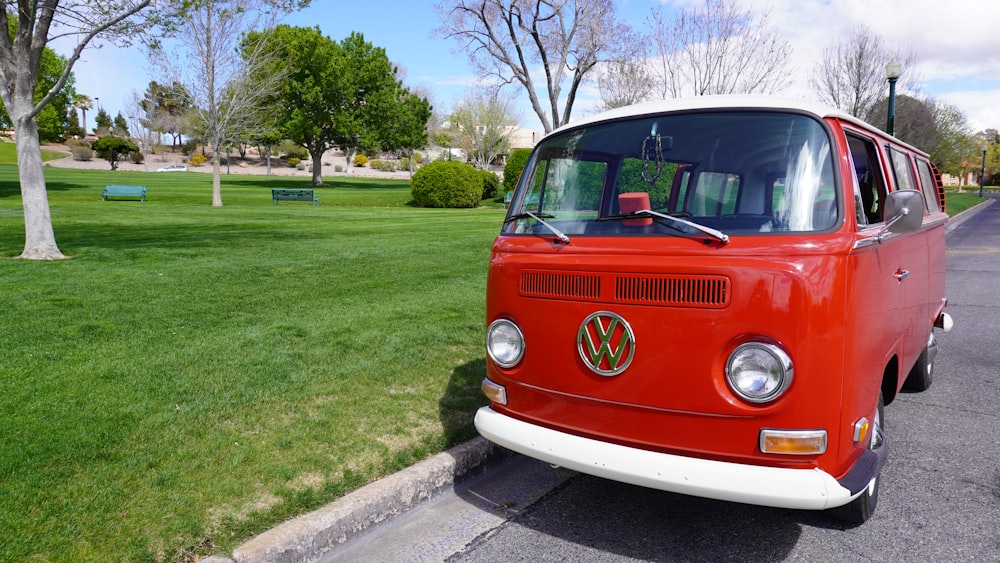 red and white volkswagen t-2 van parked on gray concrete road during daytime