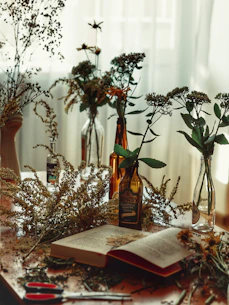 An artistic shot of scattered handwritten poems and dried flowers on a wooden table.