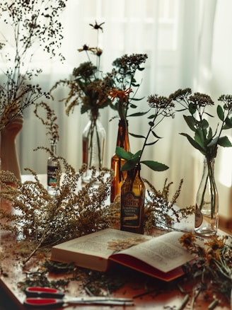 An artistic shot of scattered handwritten poems and dried flowers on a wooden table.