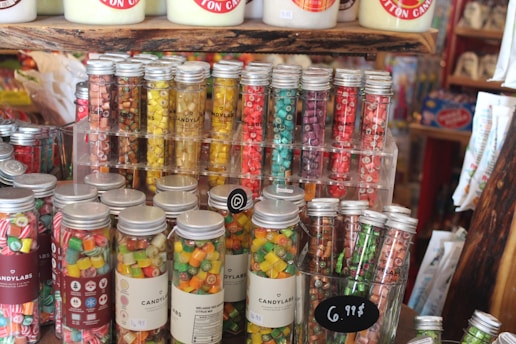 A colorful display of assorted handmade candies stacked in festive jars at Sweetfest Candies' cozy retail store.