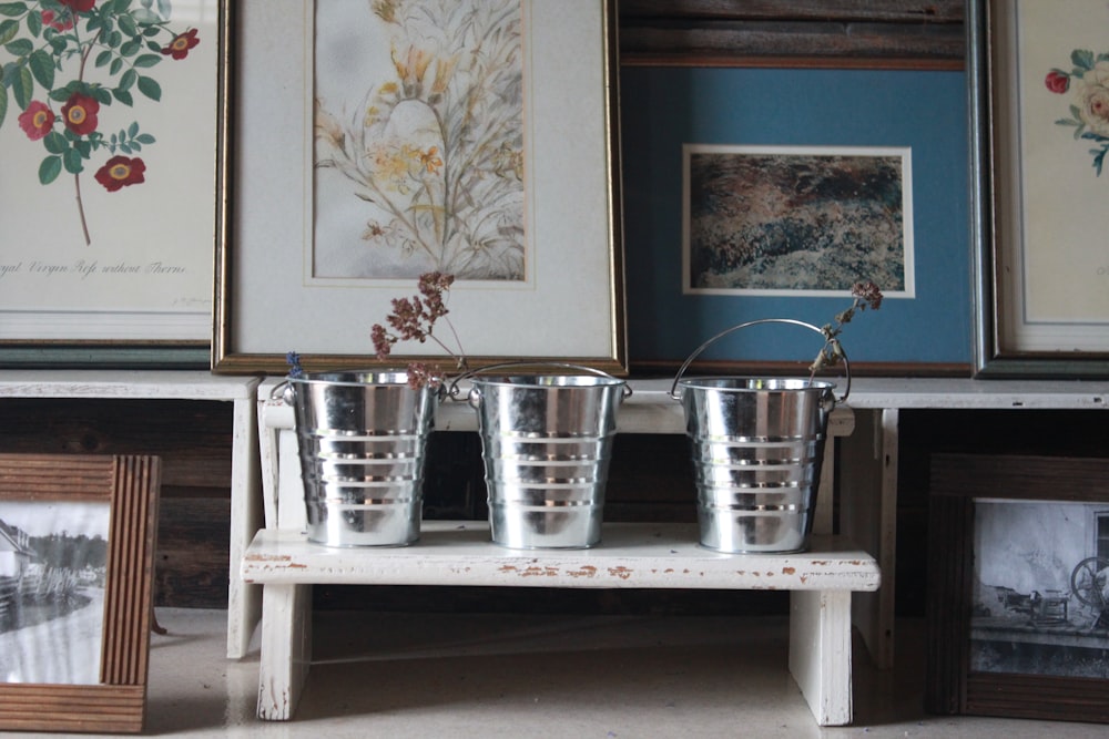 3 stainless steel cups on white wooden table