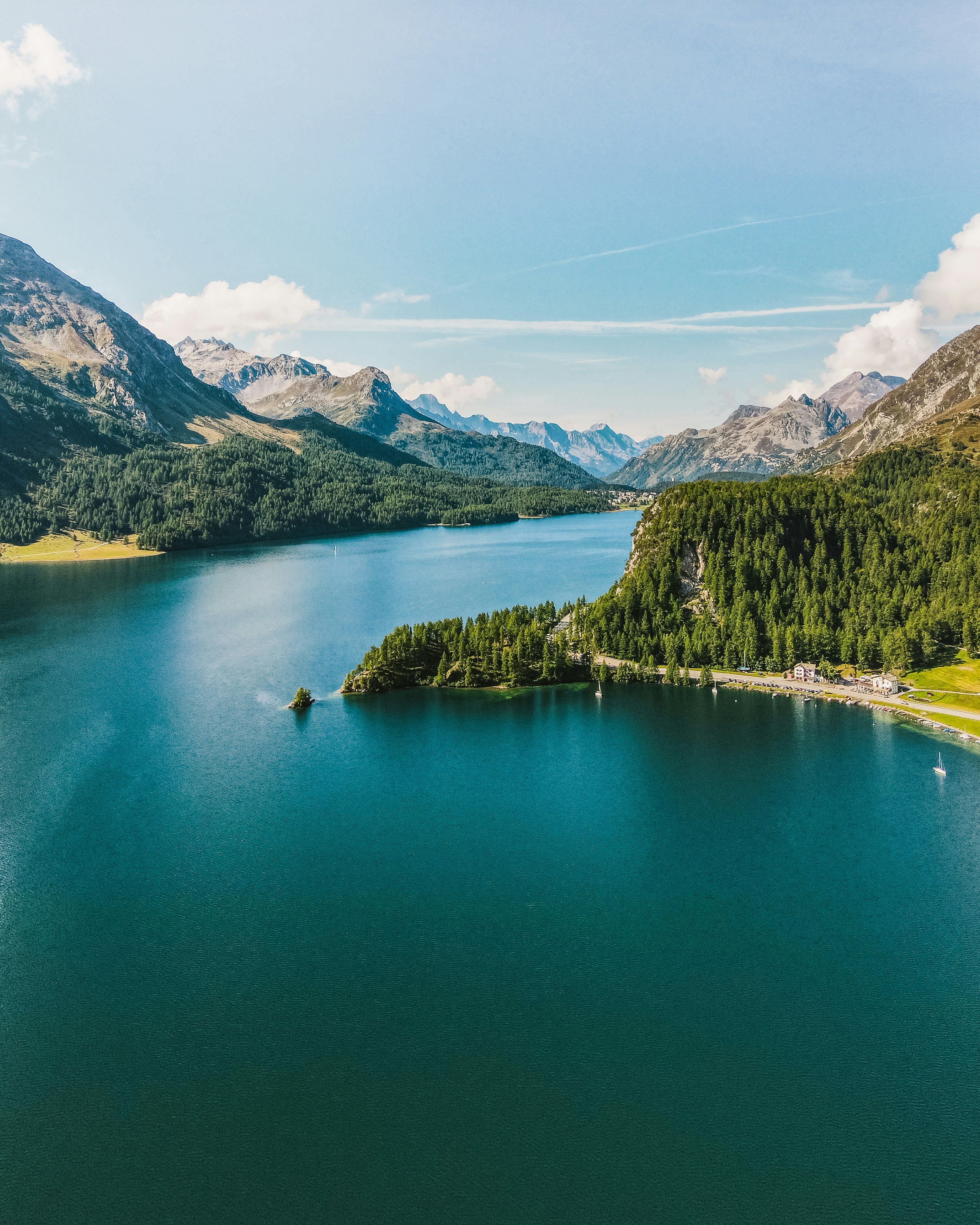 green lake surrounded by green trees and mountains during daytime