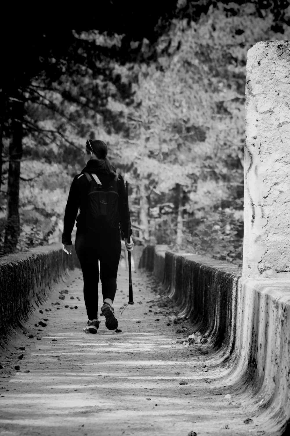 man in black jacket walking on pathway
