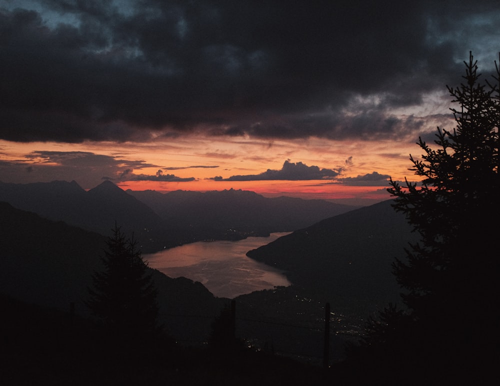 silhouette of trees and mountains during sunset