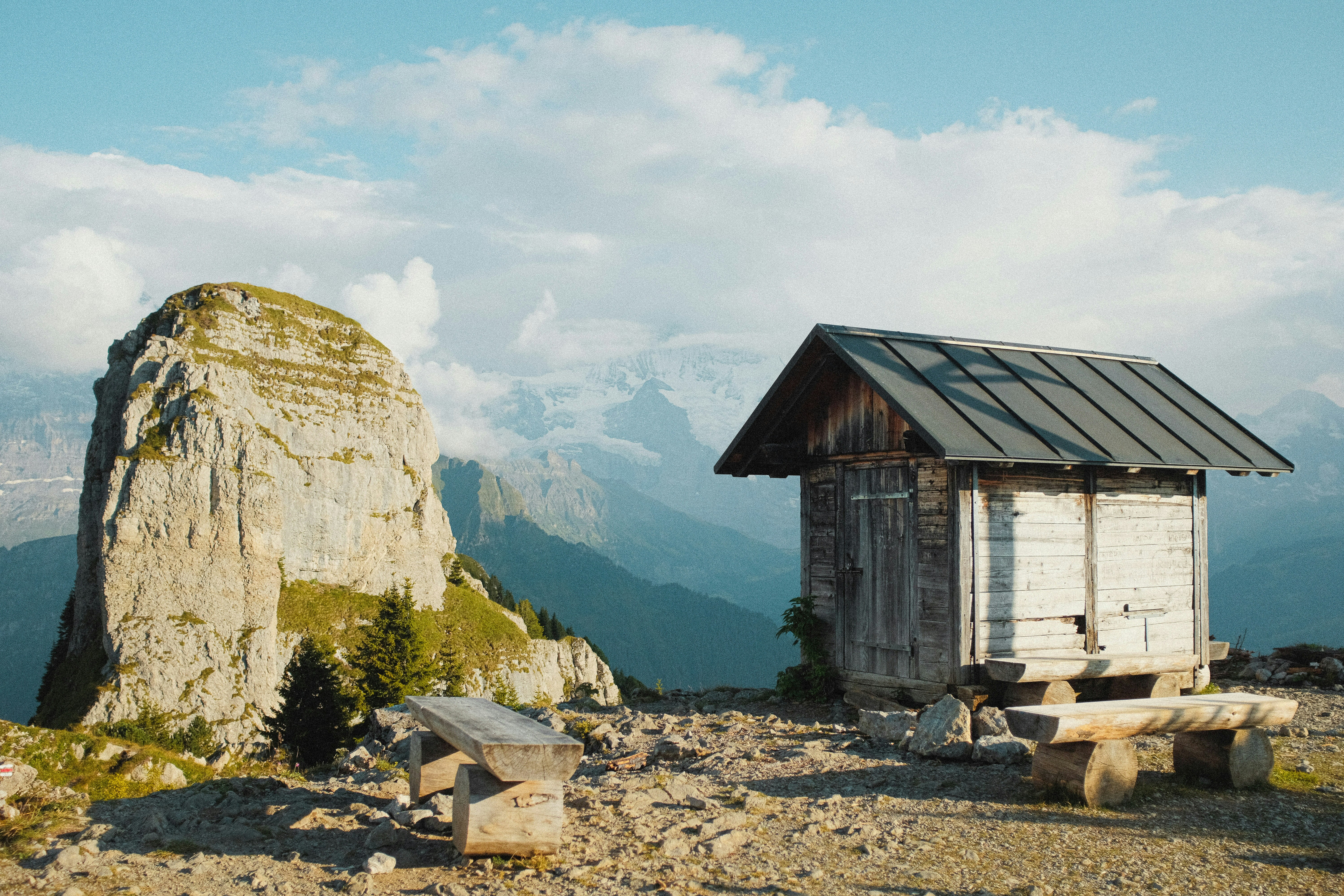 brown wooden house near green trees and mountain during daytime, 