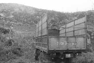 Black and white photo of a large truck loaded and ready on an open highway.