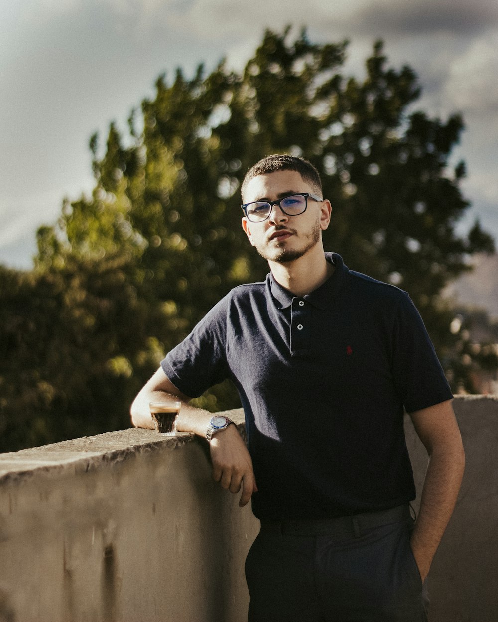 a man leaning on a wall with his hands on his hips