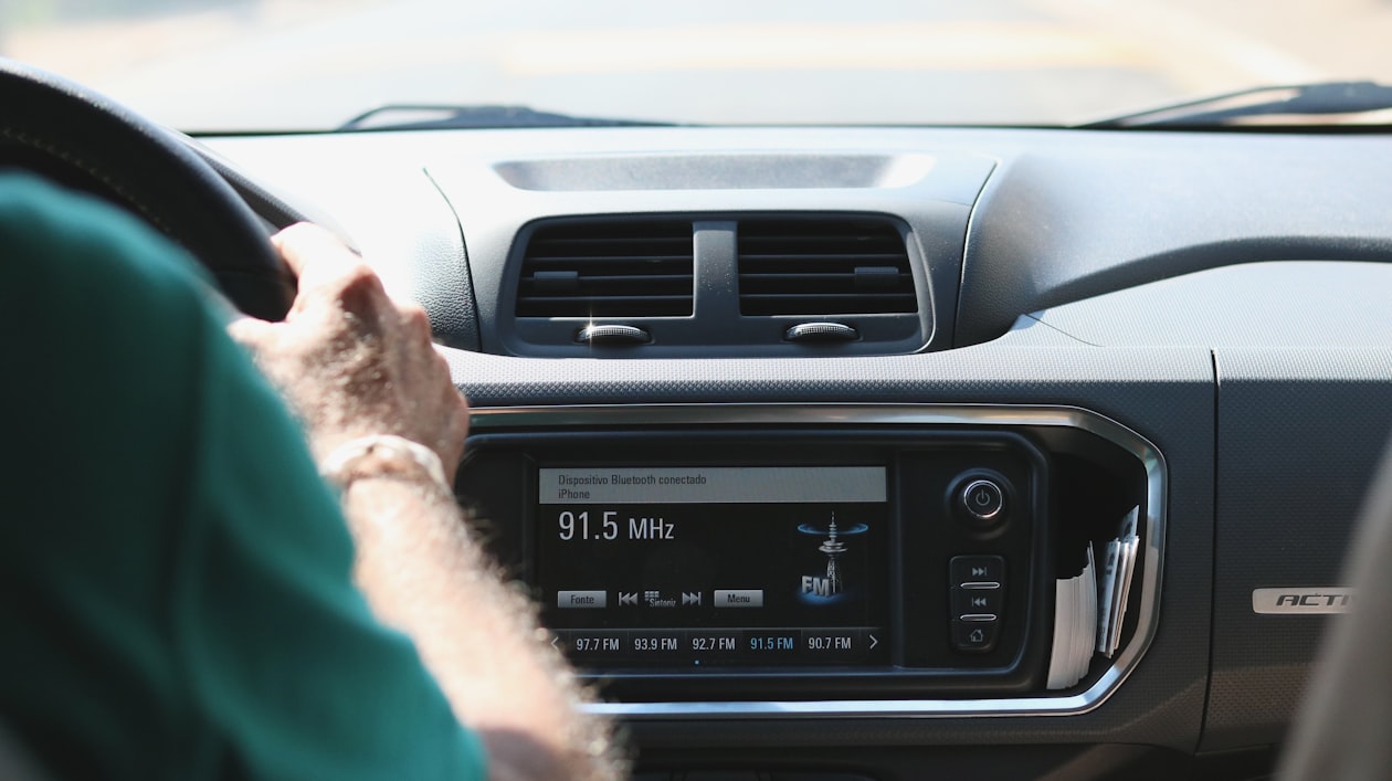 Modern aftermarket car head unit lit up and active on a vehicle dashboard showing the stereo face