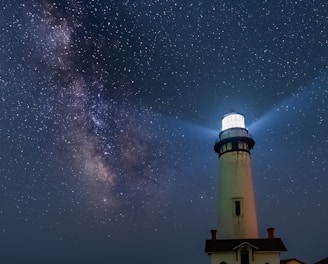 white and black light house under starry night