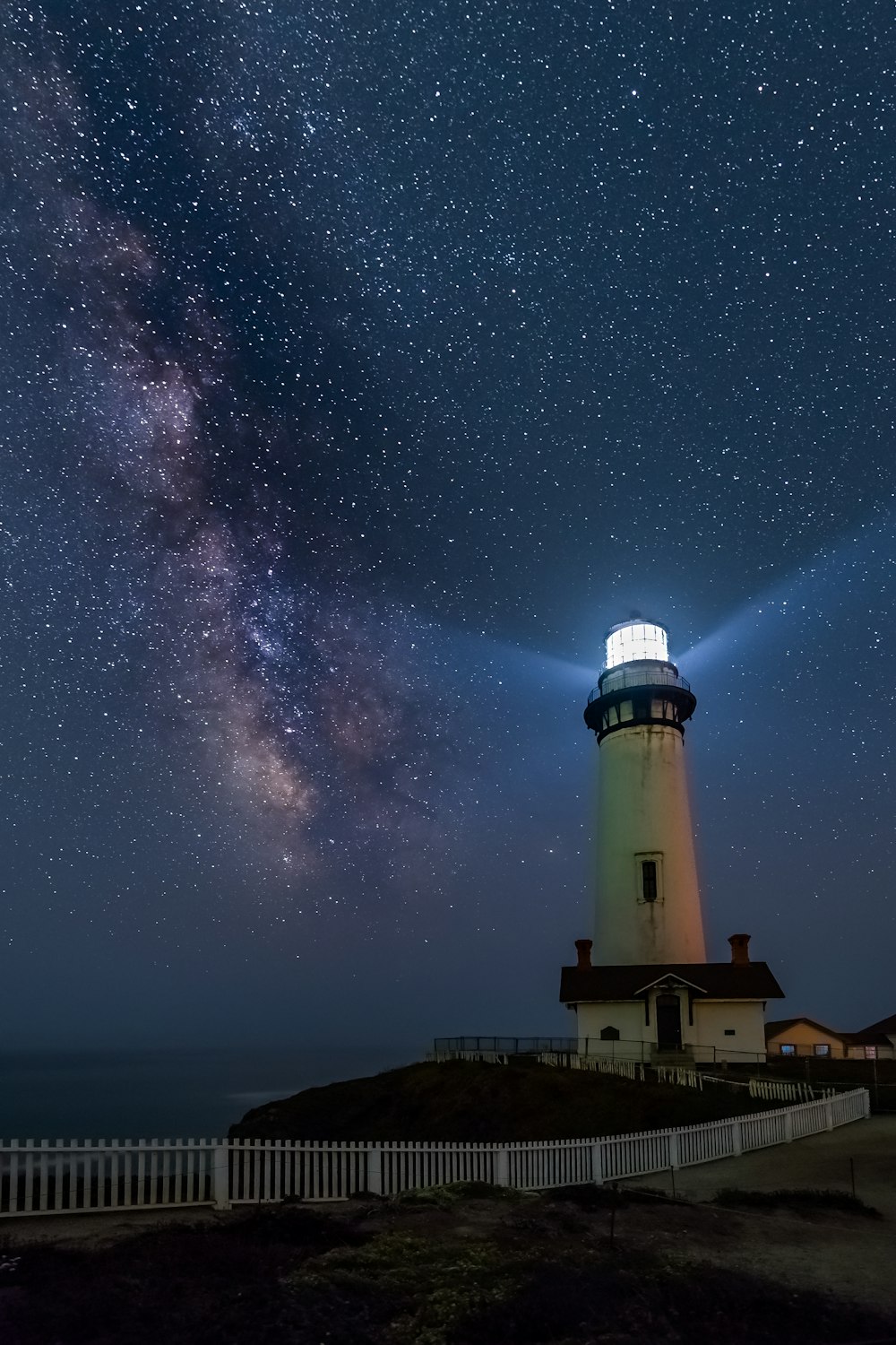 farol branco e preto sob noite estrelada