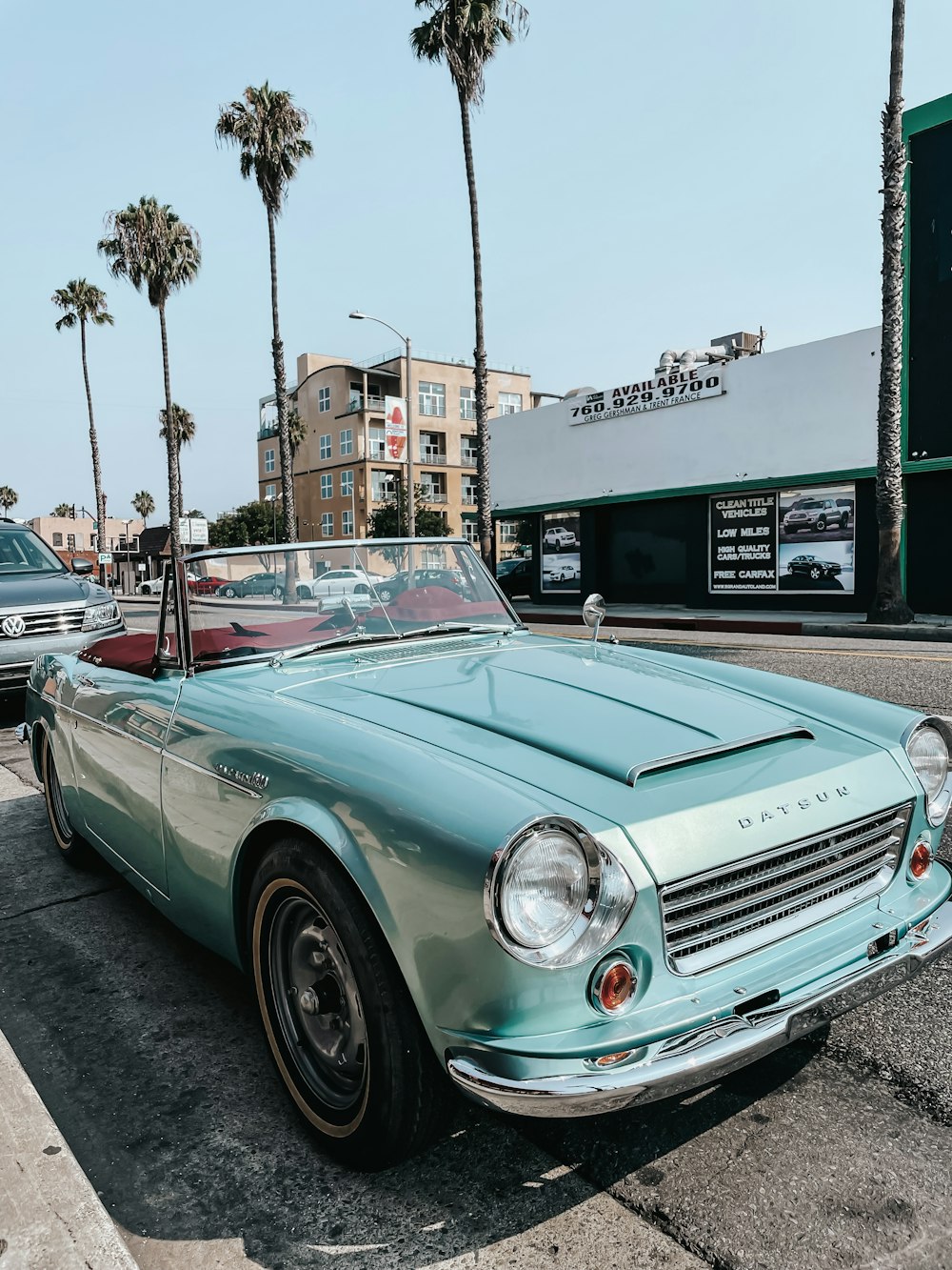 Auto verde acqua parcheggiata vicino al negozio durante il giorno