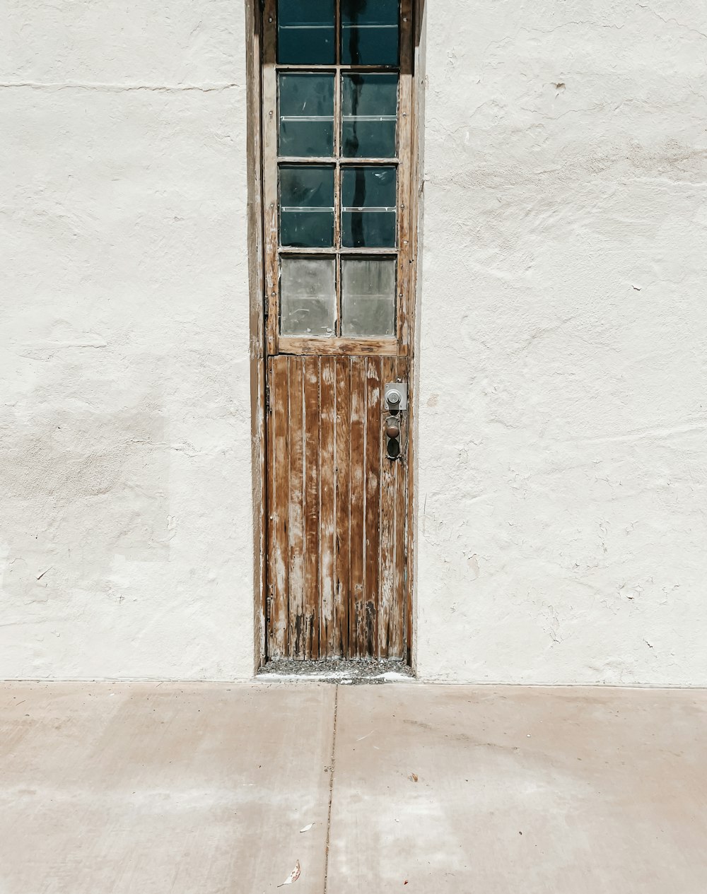 brown wooden door on white concrete wall