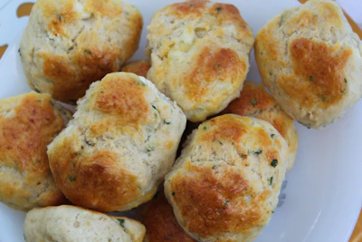 Savory herb and cheese scones stacked invitingly on a plate.