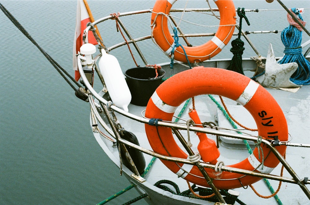 orange and white life buoy on white boat
