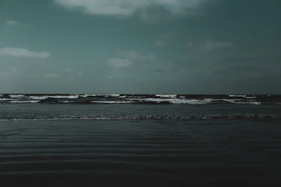 A quiet beach scene with subtle shadows and a minimalist color palette.