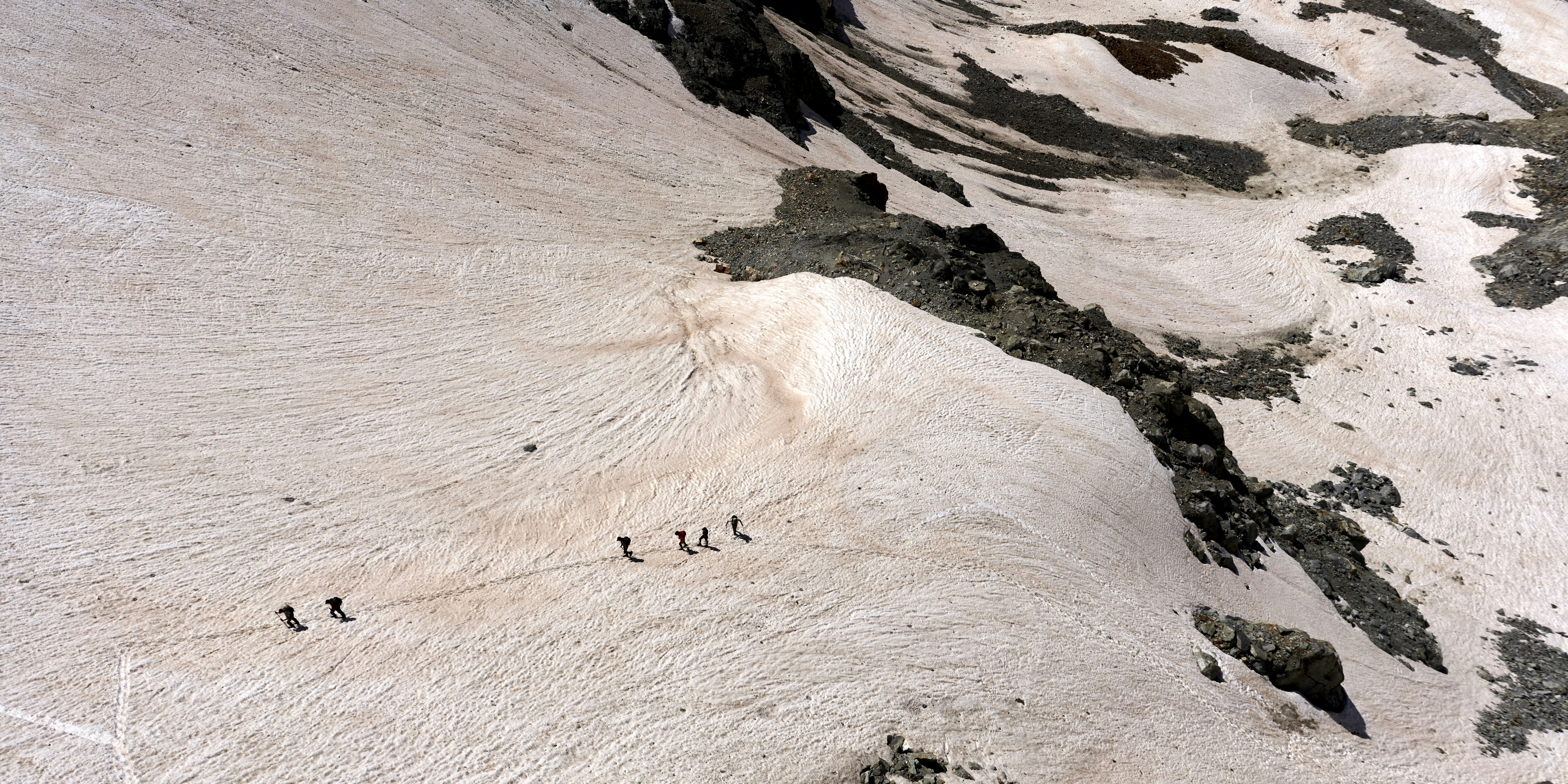 Mountainners climbing the Glacier de Bertol as seen from Cabane Bertol.
