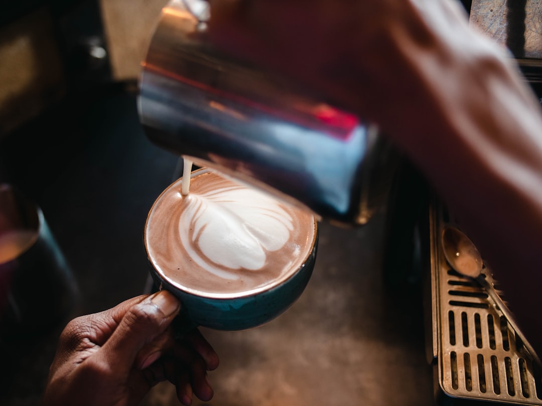 person holding stainless steel cup with white liquid