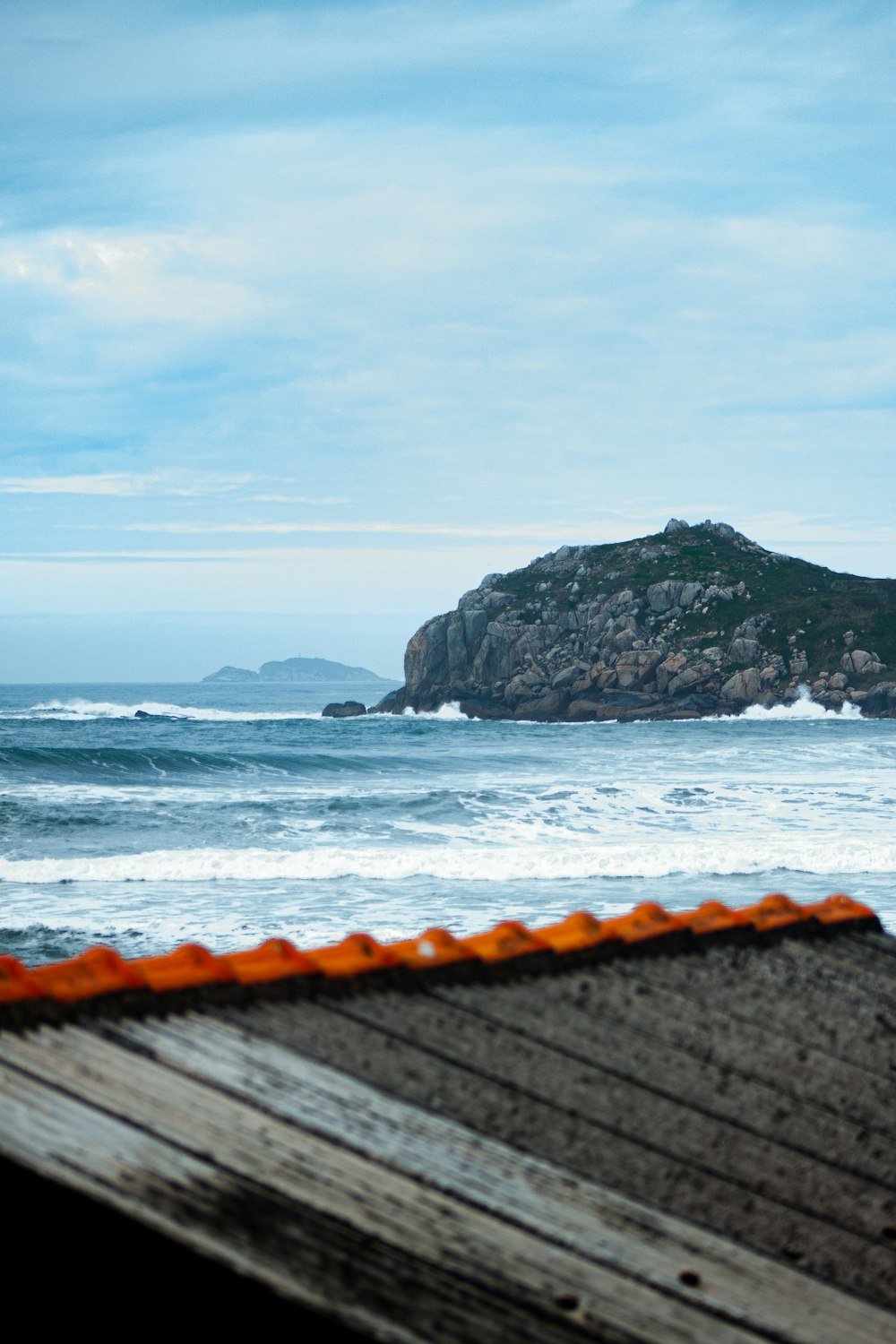 gray rocky mountain beside sea during daytime