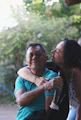 woman in white tank top kissing woman in black and white polka dot tank top