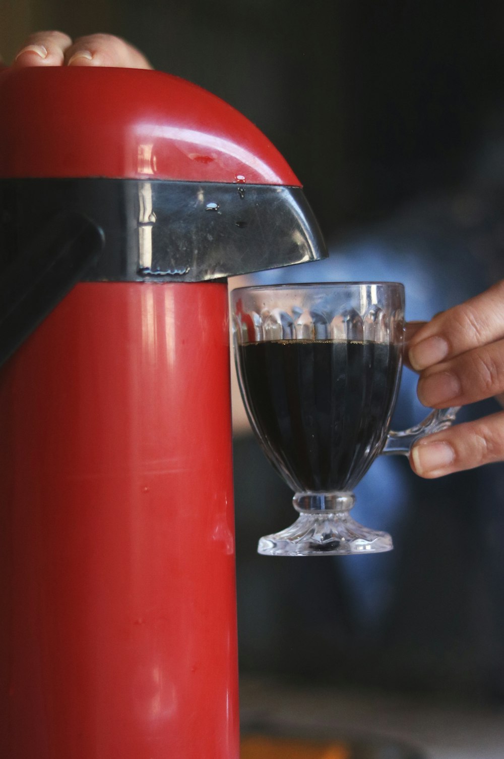 person holding red and silver water dispenser