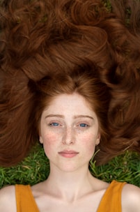 woman in green shirt lying on brown grass