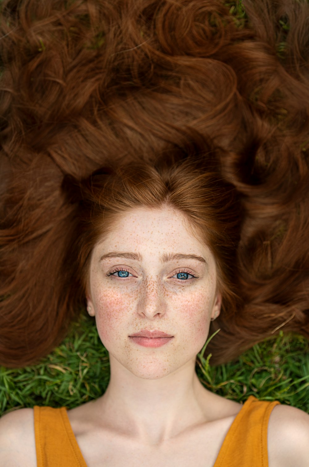 woman in green shirt lying on brown grass