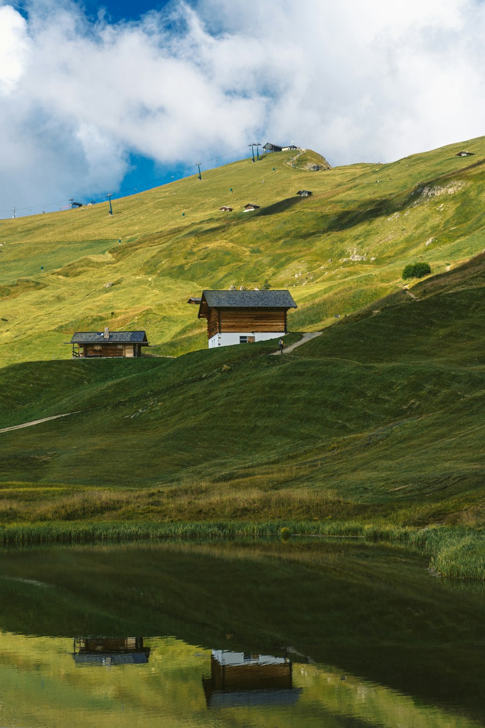 brown house on green grass field under blue sky during daytime