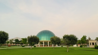A community dome structure surrounded by trees and open sky.