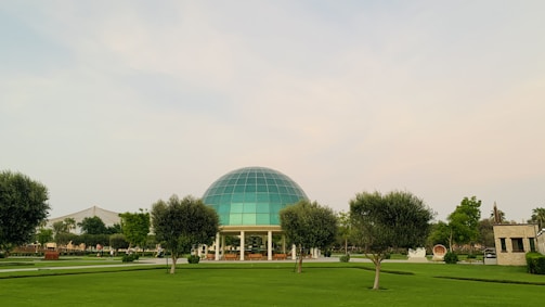 A community dome structure surrounded by trees and open sky.