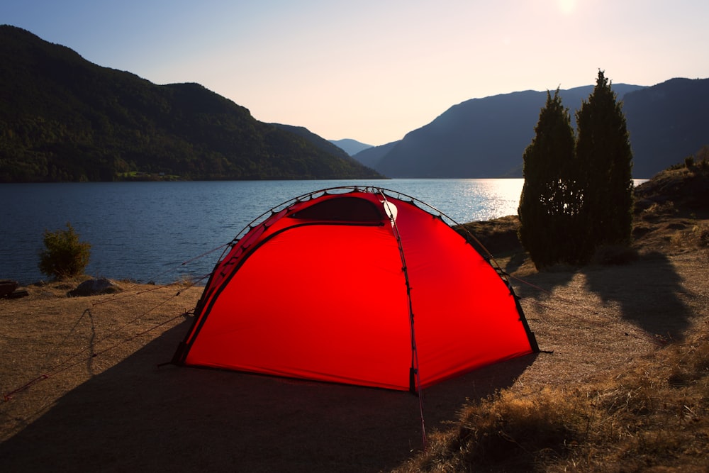 tenda de cúpula vermelha perto do corpo de água durante o dia