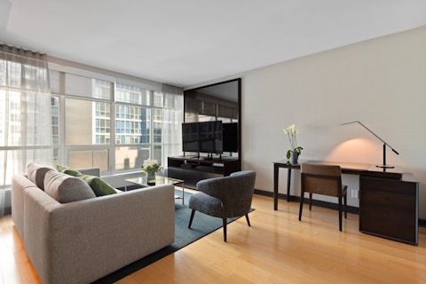 gray sectional couch beside brown wooden table