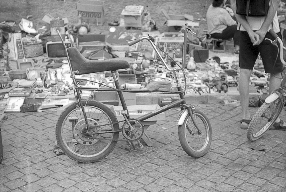 grayscale photo of city bicycle parked on sidewalk