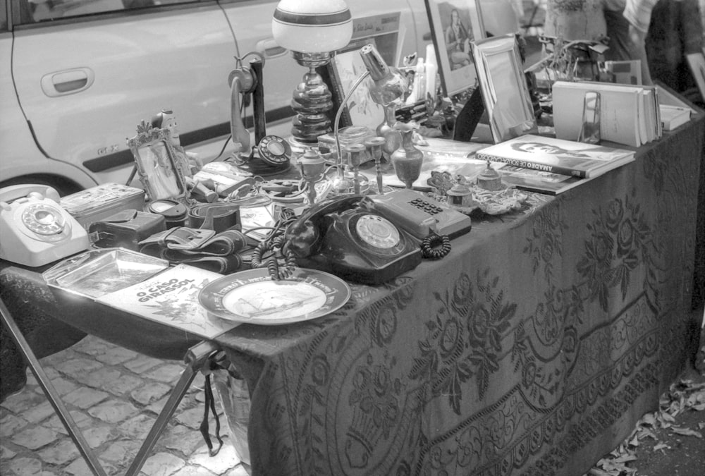 grayscale photo of table with plates and mugs