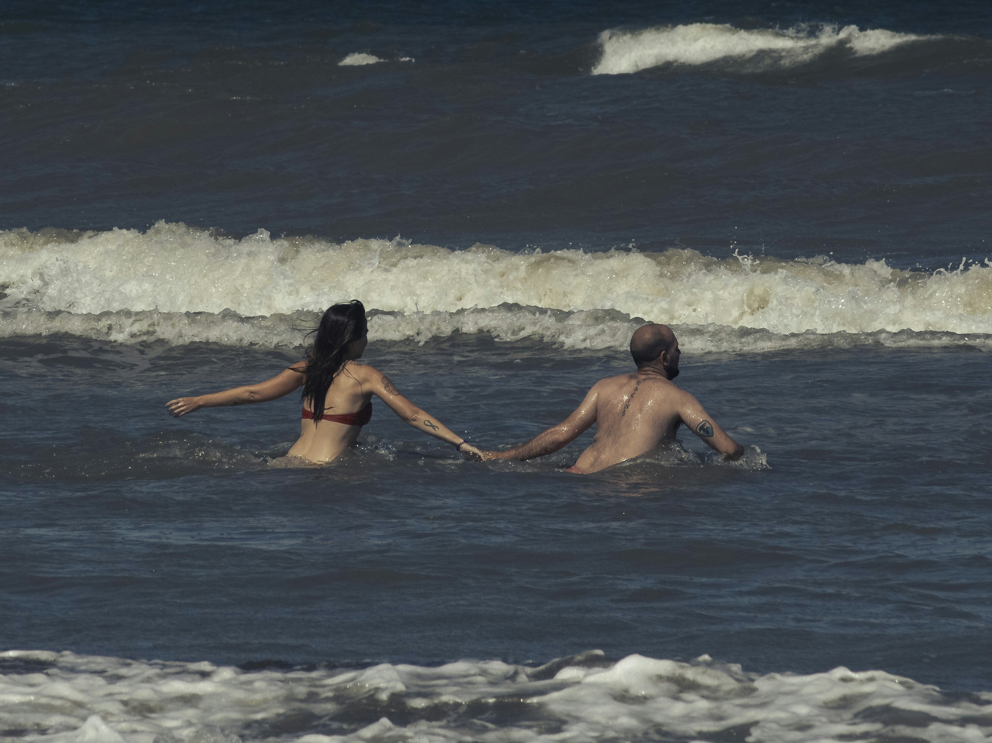 man and woman in water during daytime