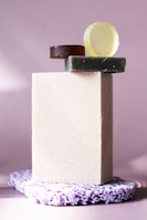 A minimalist shot of lurexo’s bath soap bars stacked elegantly on a black tray with golden accents.