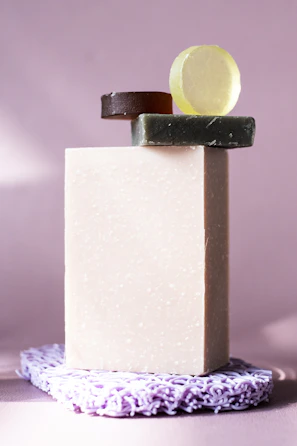 A minimalist shot of lurexo’s bath soap bars stacked elegantly on a black tray with golden accents.