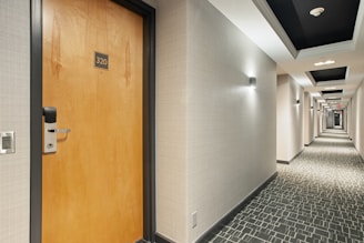 brown wooden door on white and black ceramic tiles