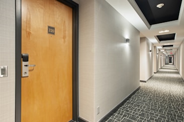 brown wooden door on white and black ceramic tiles