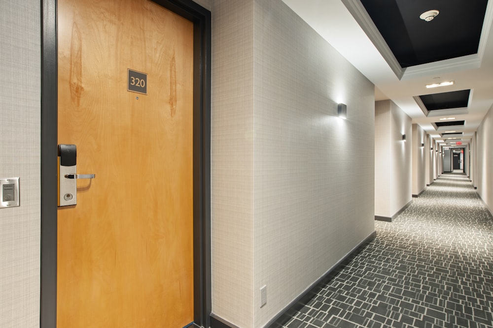 brown wooden door on white and black ceramic tiles