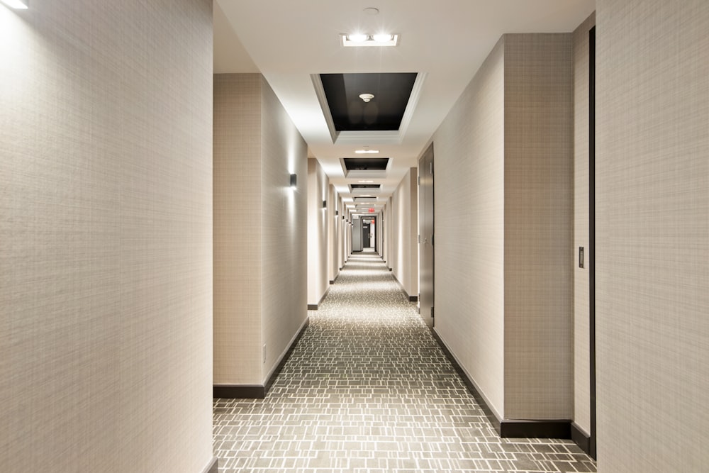 white and black hallway with lights turned on in the middle