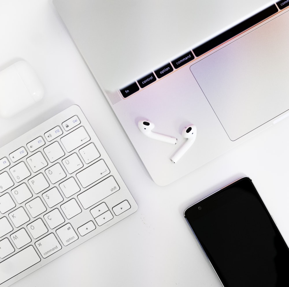 white apple keyboard beside white iphone 5 c