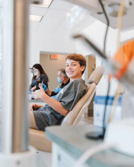 man in blue denim jacket sitting on chair