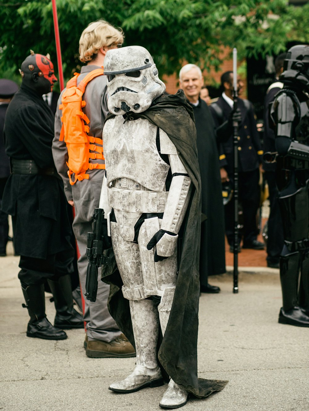 person in gray and orange jacket standing near gray statue during daytime