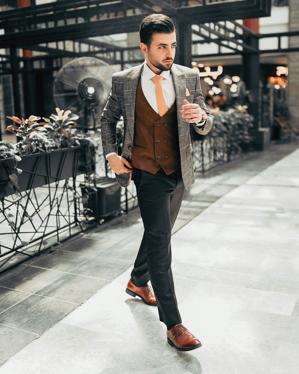 man in black suit jacket and black pants standing on white floor