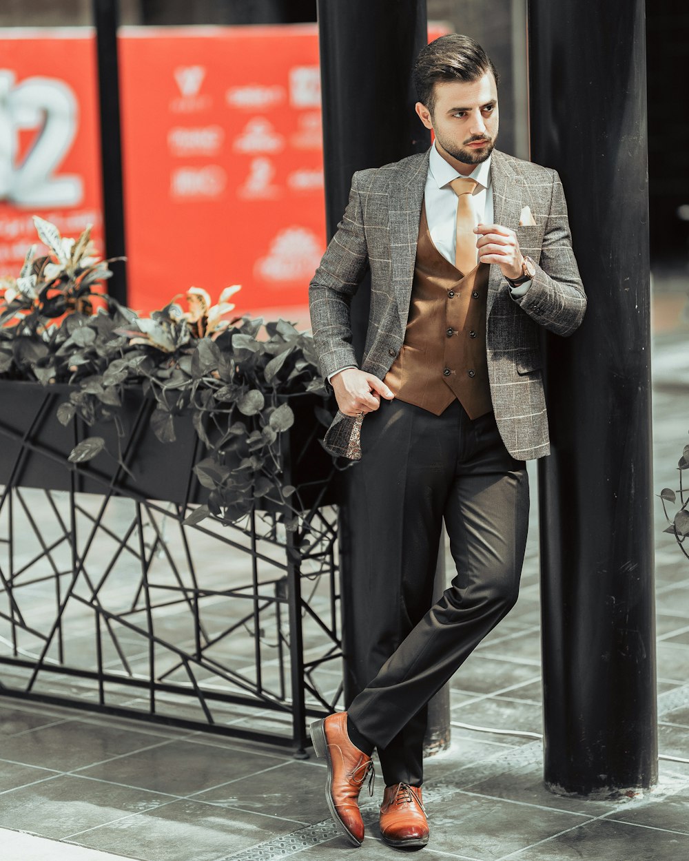 man in black suit jacket and black pants sitting on black metal bench