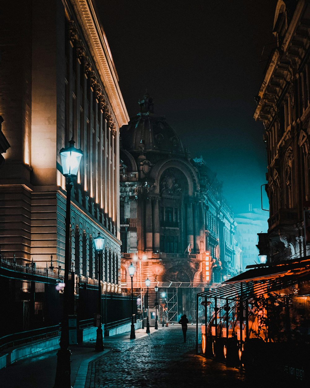 people walking on sidewalk near building during night time