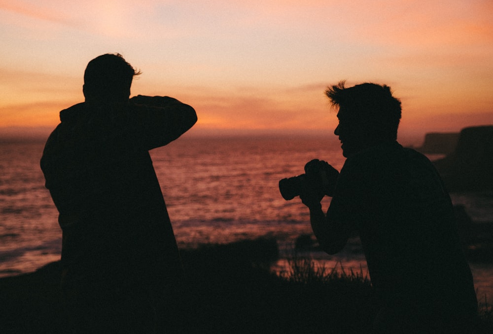 silhouette of man and woman kissing during sunset