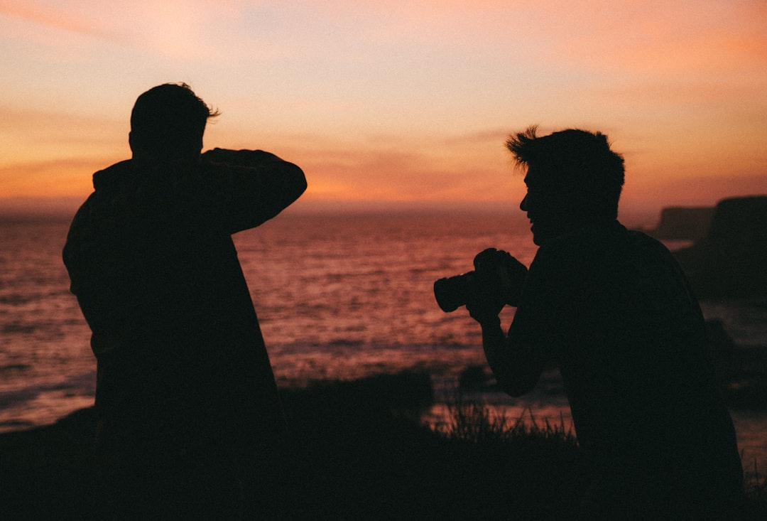 silhouette of man and woman kissing during sunset